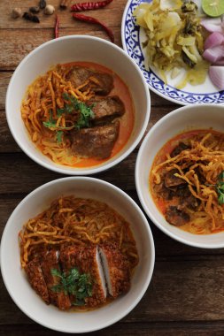 Kuzey Tayland yemekleri, ahşap arka planda domuz eti ve sığır etli körili erişte.