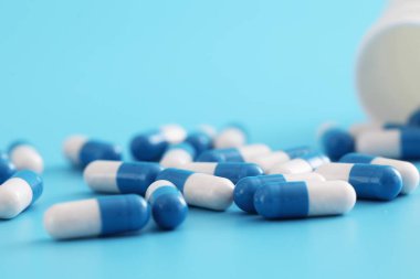 Mavi arka planda izole edilmiş şişe kapsülleri