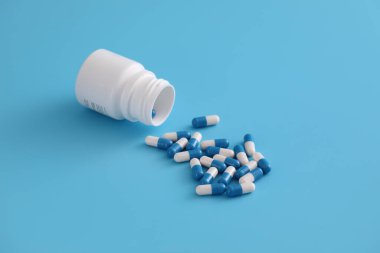 Mavi arka planda izole edilmiş şişe kapsülleri