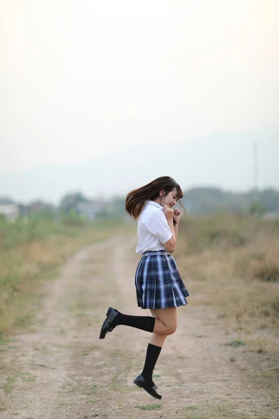 beautiful asian japanese school girl uniform jumping at walkway