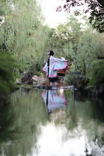 Japan anime cosplay portrait of girl with comic costume with japanese theme garden