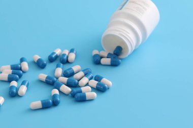 Mavi arka planda izole edilmiş şişe kapsülleri