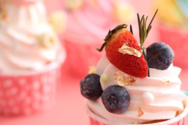 Pembe arkaplanda izole edilmiş renkli kekler