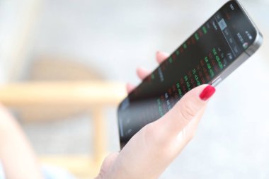 Akıllı telefon ile kadın eli Kafe İş Konseptinde hisse senedi ticareti