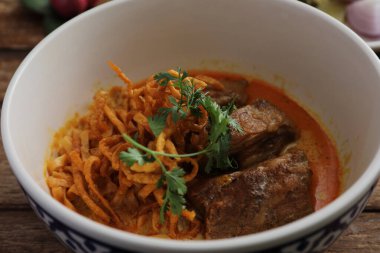 Kuzey Tayland yemekleri, ahşap arka planda domuz pirzolası ve körili erişte.