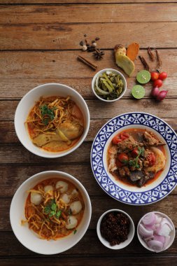 Kuzey Tayland yemekleri tavuk, köfte ve ahşap zemin üzerinde pirinç eriştesi ile körili erişte.