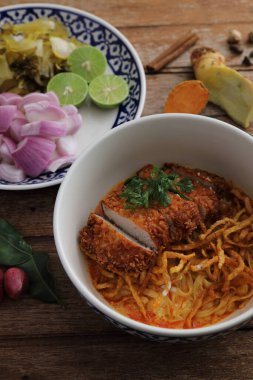 Kuzey Tayland yemekleri, ahşap arka planda kızarmış domuz etli körili erişte.