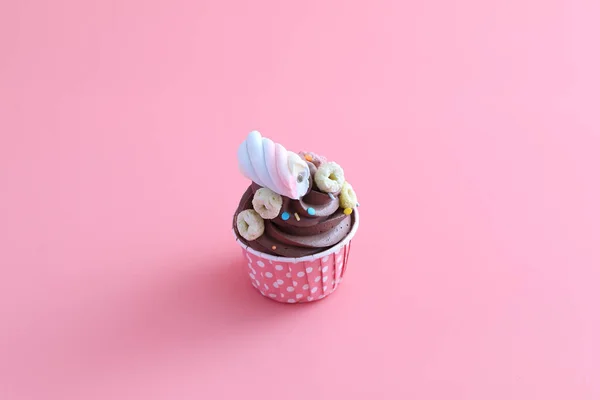 ピンクの背景に隔離されたチョコレートカップケーキ — ストック写真