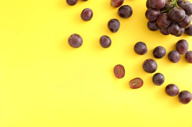 Kırmızı üzümler sarı arkaplanda izole edilmiş üst görünüm