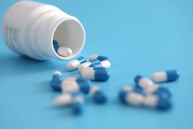 Mavi arka planda izole edilmiş şişe kapsülleri