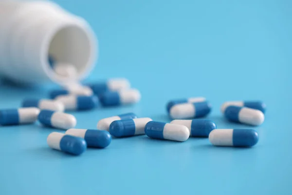 Pastillas Cápsulas Con Botella Aislada Sobre Fondo Azul —  Fotos de Stock