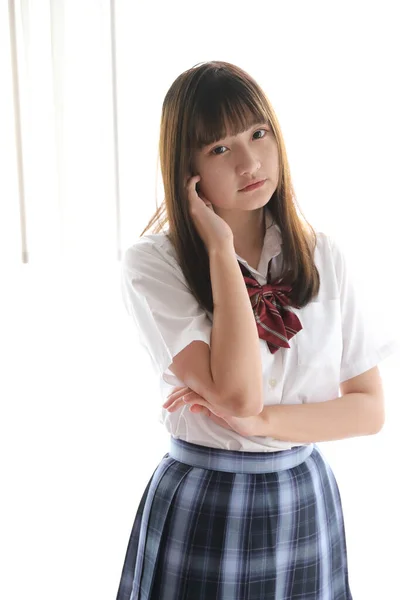 ポートレート日本語学校の女の子制服でホワイトトーンベッドルーム — ストック写真