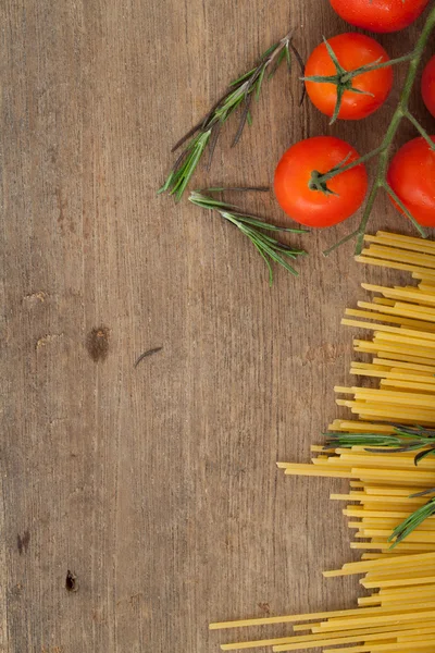 Espaguetis con tomates albahaca sobre fondo de madera — Foto de Stock