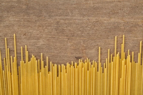 Spaghetti z bazylią pomidory na tle drewna — Zdjęcie stockowe