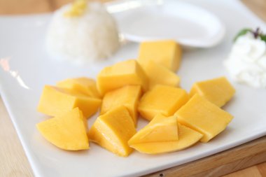 Ahşap zemin üzerinde mango olan yapışkan pirinç.