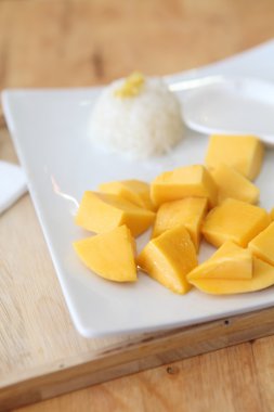 Ahşap zemin üzerinde mango olan yapışkan pirinç.