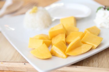 Ahşap zemin üzerinde mango olan yapışkan pirinç.