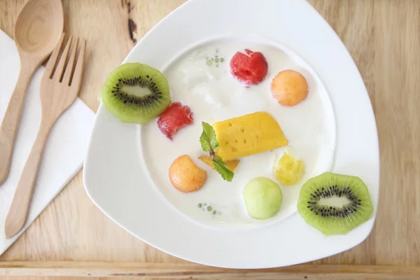 Yogurt with fruit on wood background — Stock Photo, Image