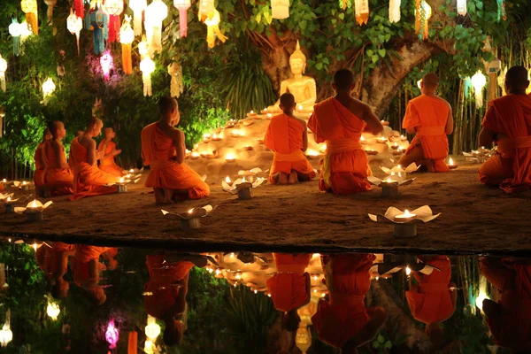 Thaise monniken mediteren rond Boeddhabeeld onder vele lantaarns — Stockfoto