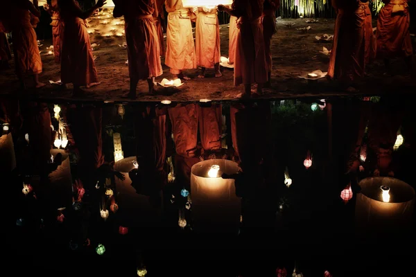 Thai monks meditate around buddha statue among many lanterns — Stock Photo, Image