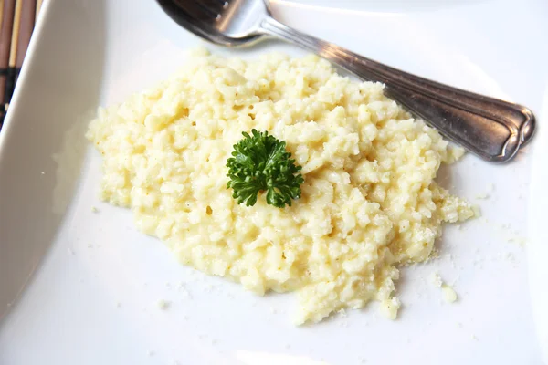 Risotto schotel met kruiden op houten achtergrond — Stockfoto