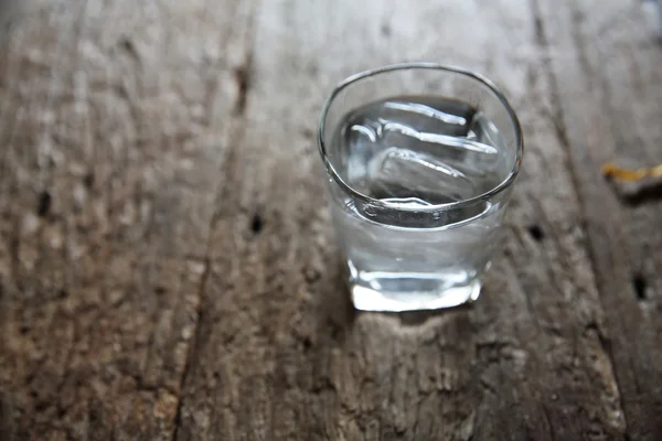 Water in glas in hout achtergrond — Stockfoto