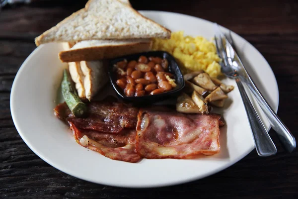 Ontbijt met ham, gebakken ei en brood op houten achtergrond laag — Stockfoto