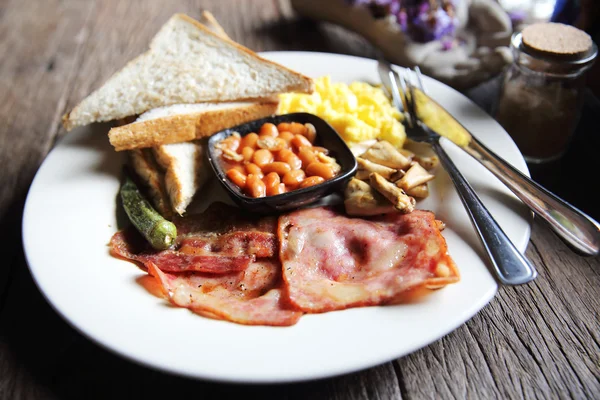 Ontbijt met ham, gebakken ei en brood op houten achtergrond laag — Stockfoto