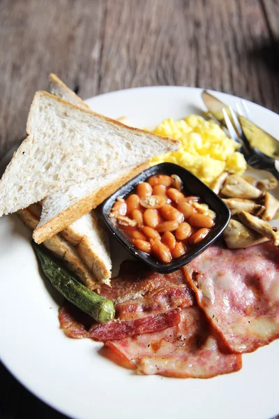 Ontbijt met ham, gebakken ei en brood op houten achtergrond laag — Stockfoto