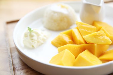 Ahşap zemin üzerinde mango olan yapışkan pirinç.