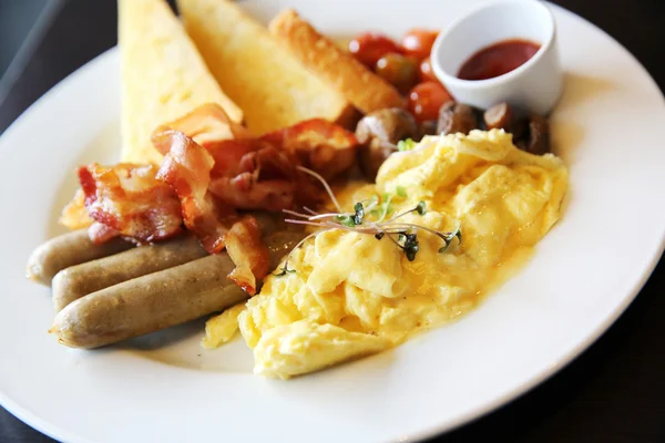 Petit déjeuner américain avec bacon, oeuf brouillé sur fond de bois — Photo