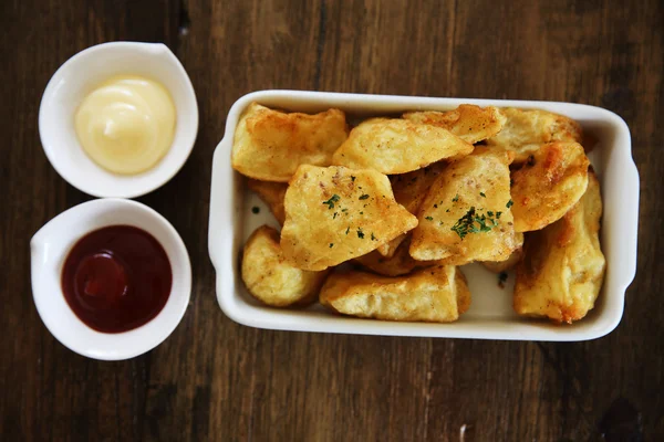 Batatas fritas no fundo de madeira — Fotografia de Stock