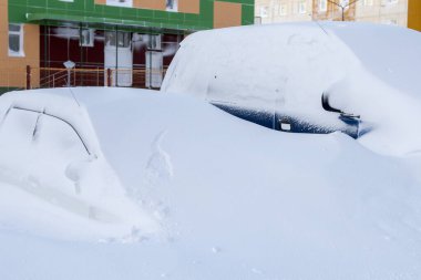 Araba kar fırtınasından sonra büyük bir kar yığınının altında gömülü.