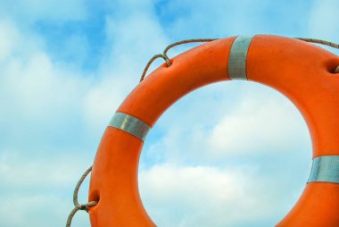 Mavi gökyüzünün arka planında bir can simidi.