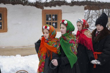  Noel kutlaması. Ukrayna halk geleneklerine göre, Ukrayna kostümlü köy çocukları Noel şarkıları söylüyor, her evde yeni yılda mutluluğu çağırıyorlar KIEV, UKRAINE