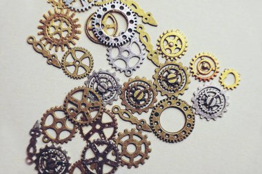 Bronz, gümüş ve altın dişlilerden yapılmış bej arkaplanlı kalp şeklinde makineler hakkında bir steampunk ve eski düz makro.