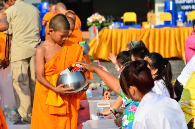 İnsanlar budist bir mon'a yiyecek ikramı