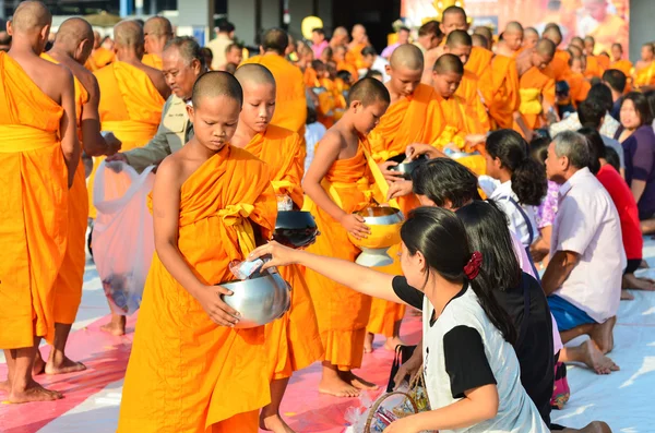 Människor ger mat erbjudanden till en buddhistisk mån — Stockfoto