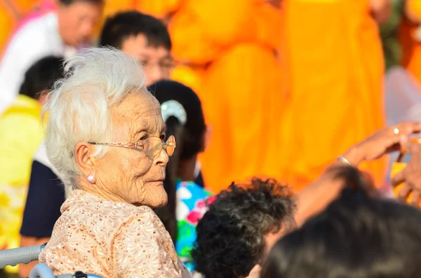 Människor ger mat erbjudanden till en buddhistisk mån — Stockfoto