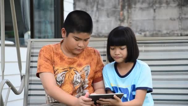 Irmãos asiáticos usando tablet . — Vídeo de Stock