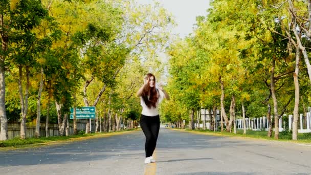 Ung kvinne hopper om sommeren på gaten . – stockvideo