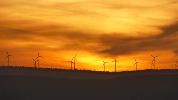 Silhouettes de parcs d'éoliennes électriques au lever du soleil . — Video