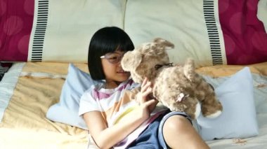 Asya oyuncak ayı oynarken küçük kız.