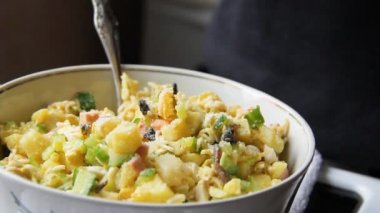 Tencerede salata. Kız salataya mayonez koyuyor. Yemek pişirmek.