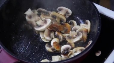 Mantarlar tavada kızartılır. Şampiyon. Şef mantar kızarttı.