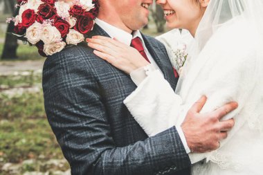 Gelin ve damat birlikte yaklaşın. Düğün buketi olan gelin. Gelinlik ve kırmızı kravat. Düğün.