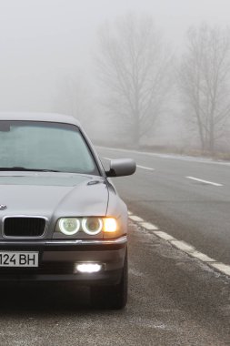 Chernigov, Ukrayna - 6 Ocak 2021: Eski BMW 7 Serisi (E38) sis arka planında. Kasvetli hava. Bmw ve sis