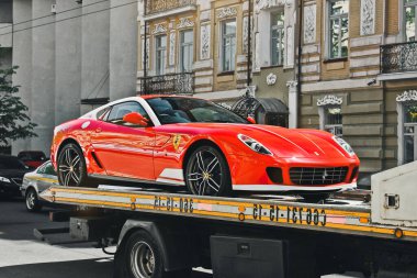 Kiev, Ukrayna - 12 Mayıs 2012: Kırmızı süper araba Ferrari 599 Alonso Edition 60F1 şehirde. Çekicide bir araba.
