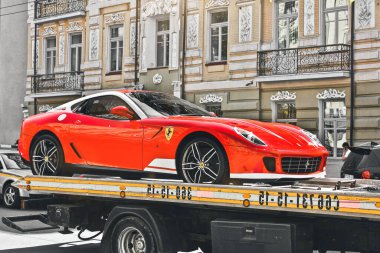 Kiev, Ukrayna - 12 Mayıs 2012: Kırmızı süper araba Ferrari 599 Alonso Edition 60F1 şehirde. Çekicide bir araba.