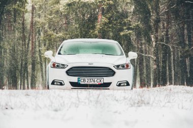 Chernigov, Ukrayna - 28 Ocak 2021: karlı bir ormanda beyaz Ford arabası. Güzel kış